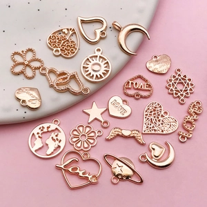 Macro view of assorted rose gold charms featuring hollow hearts and Love motifs on tray