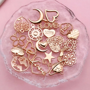 Macro view of assorted KC gold hollow heart and LOVE charms on a pink glass tray
