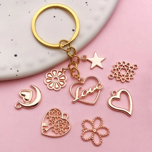 Rose gold keychain set featuring hollow Love heart, stars, and moon pendants on a tray