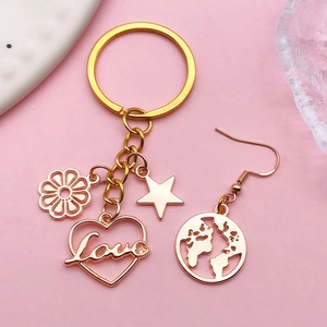 Detail of rose gold Love heart and star pendants on a keychain and map earrings