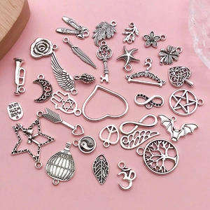 Close-up of vintage silver alloy charms featuring wings, hearts, and trees for DIY jewelry