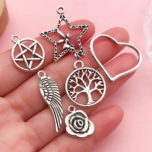 Detailed macro of vintage silver alloy charms featuring angel wings and rose flower pendants