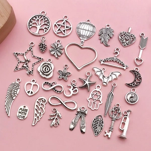 Macro shot of vintage silver alloy charms featuring tree of life and heart shapes for DIY