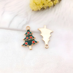 Dettaglio del ciondolo ad albero di Natale in smalto verde con doratura e trama sul retro