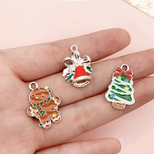 Macro shot of colorful enamel Christmas charms held in hand to show size and DIY details