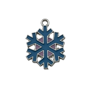 Detailed macro view of a dark blue and purple enamel snowflake pendant with metal frame