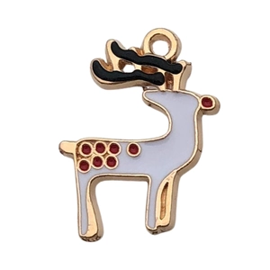 Macro detail of reindeer pendant with gold metal frame and red dotted enamel finish
