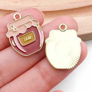 Detalle de colgantes de tarro de mermelada en esmalte rojo con reverso de metal dorado