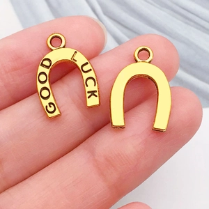 Detail of lucky horseshoe charms in gold finish with Good Luck engraving for jewelry DIY