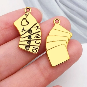 Detailed close-up of gold royal flush playing card charms showing front and back design