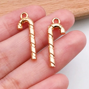 Primer plano de dijes de bastón de caramelo en oro rosa para creación de joyas DIY