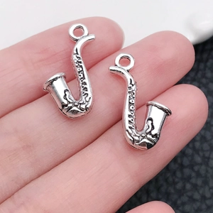 Makroaufnahme von zwei silbernen Saxophon-Anhängern aus Zinklegierung für Schmuck