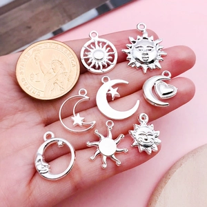 Pendentifs célestes en argent avec soleil lune et étoiles à côté d'une pièce d'un dollar