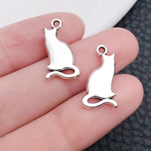 Nahaufnahme des antik-silbernen Katzenanhängers in der Hand für DIY-Schmuck