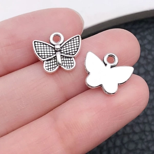 Vue macro d'un pendentif papillon argenté montrant la texture détaillée pour bijoux DIY
