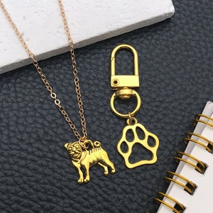 Ensemble collier carlin doré et porte-clés patte sur fond de cuir noir élégant