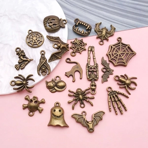 Detailed close-up of antique bronze alloy Halloween charms including pumpkins and spiders