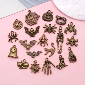 Flat lay of antique bronze alloy Halloween charms including spider webs and pumpkins