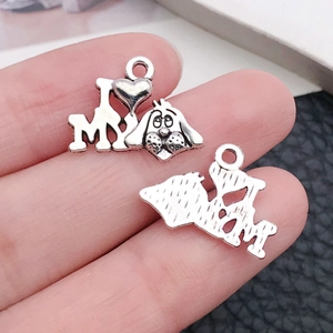 Gros plan de breloques chien en argent pour DIY avec gravure cœur et vue de l'envers
