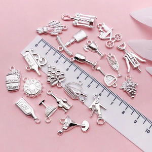Silver wine charms collection featuring bottles and grapes next to a scale ruler