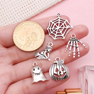 Gedetailleerde grootte van antieke zilveren Halloween-hangers naast een dollarmunt ter referentie