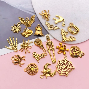 Detailed view of Halloween themed gold-tone alloy charms including skulls and spider webs