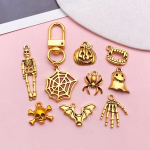 Detailed view of nine gold-finish Halloween charms featuring skulls, spiders, and ghosts