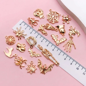 Flat lay of KC gold Halloween charms set featuring spiders and pumpkins with size ruler