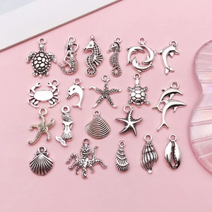 Macro view of 20 vintage silver marine pendants featuring sea turtles, seahorses and shells