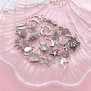 Detailed collection of antique silver ocean charms featuring sea stars, turtles, and shells