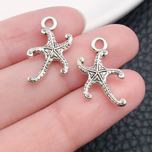 Macro shot of silver starfish charms with vintage textured details for DIY jewelry