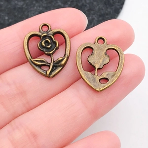 Macro detail of antique bronze heart pendant with rose relief and hollow-out design