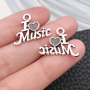 Macro shot of I love Music heart charms in vintage silver alloy for DIY jewelry making