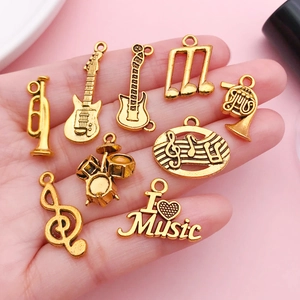 Goldenes Set aus Musikinstrument-Anhängern mit Gitarre, Schlagzeug und Noten-Motiven