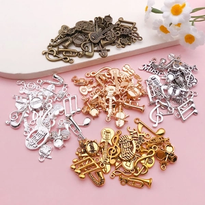 Assortiment de breloques instruments de musique en or, argent, bronze et or rose
