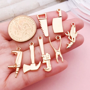 7-teiliges Set Goldlegierung Miniatur Werkzeug Anhänger mit Münze auf der Hand