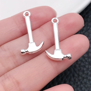 Vue macro de breloques marteau argentées pour création de bijoux DIY au fini brillant