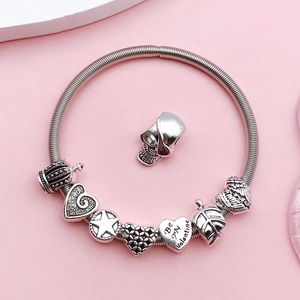 Close-up of silver charms including a Be My Valentine heart on a snake chain bracelet