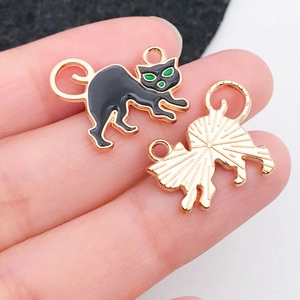 Detail of black enamel cat charm with gold-plated back and top hanging loop for DIY jewelry