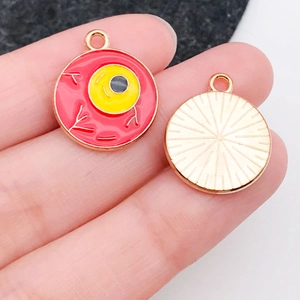 Detail of round enamel eyeball pendant with red and yellow design for DIY jewelry