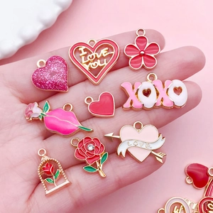 Close-up of pink enamel Valentine charms with rose heart and LOVE letter pendants