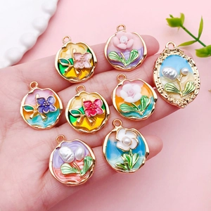 Handheld view of assorted enamel tulip flower charms for DIY jewelry and necklaces