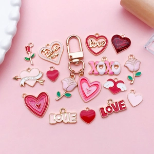 Detail of pink enamel heart and rose charms with LOVE lettering for DIY jewelry making