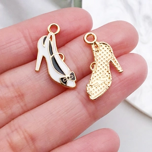 Macro view of high-heeled shoe charms with white enamel and black bow details