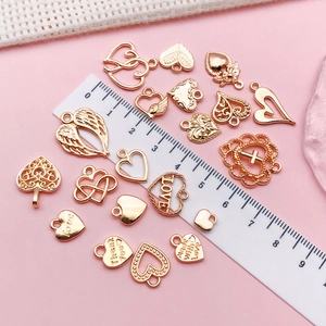 Detailed view of assorted rose gold heart and wing charms with engraved love slogans