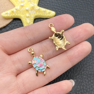 Detailed view of colorful enamel turtle charms with gold-plated finish and loop