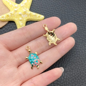 Detailed macro view showing the enamel turtle charm front and polished metal back