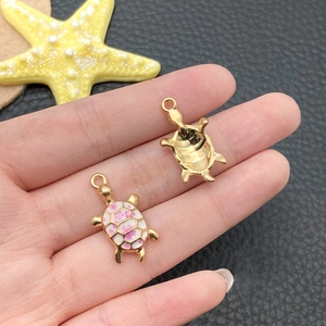 Macro detail of alloy sea turtle charms with pink floral enamel for DIY jewelry making