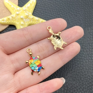 Detail of colorful enamel sea turtle pendants with gold-plated metal back for DIY crafts