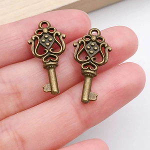 Close-up of vintage bronze alloy key pendants with intricate filigree for DIY jewelry